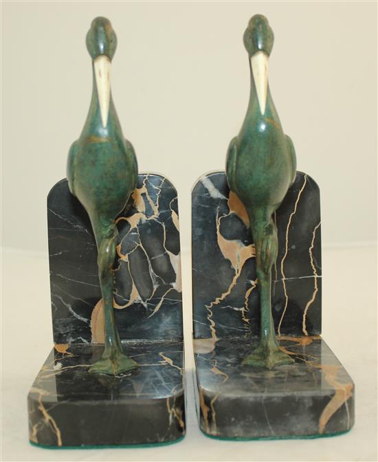 A pair of French Art Deco bronze and ivory stork bookends, 7.5in.